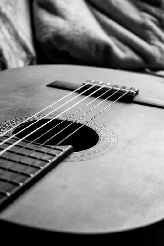 an acoustic guitar resting on top of the armrest