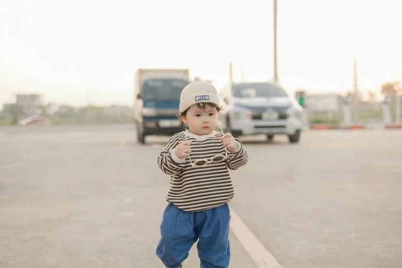 a small boy standing on the edge of a road