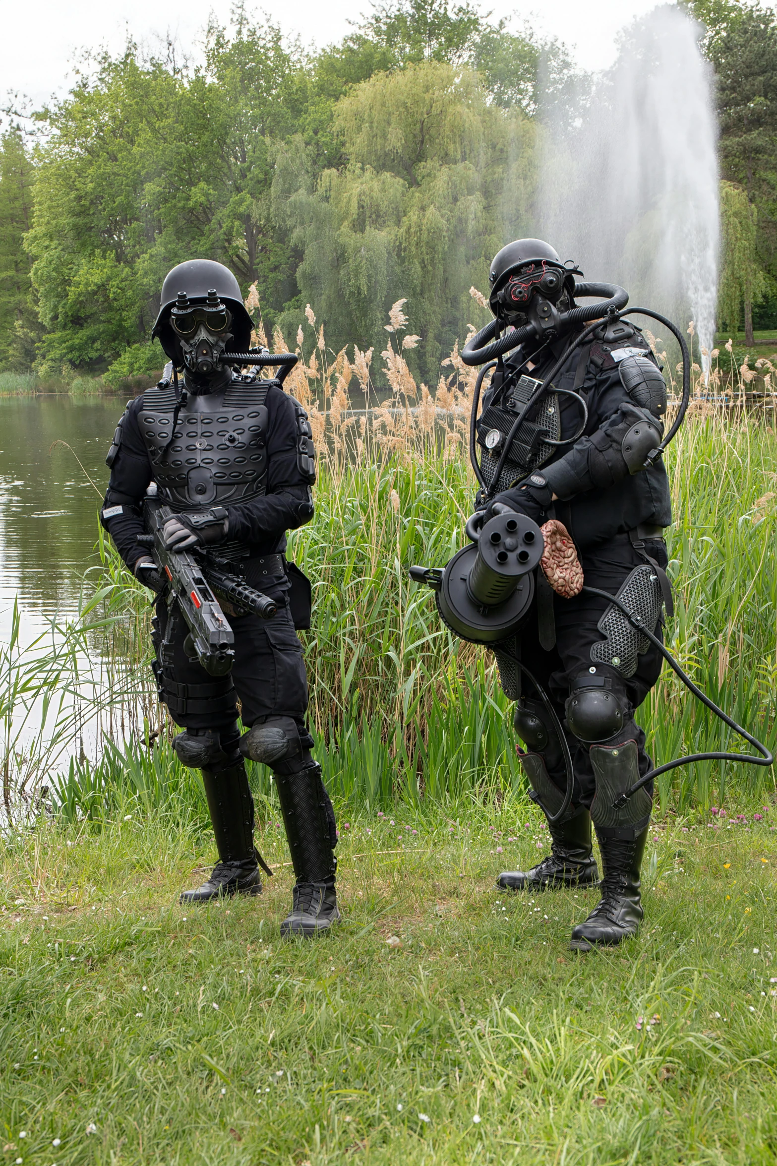 two people in gear are holding a fire hose