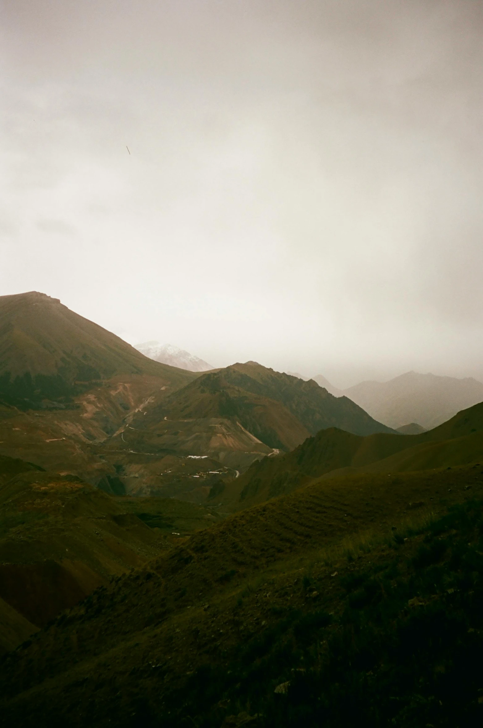 a scenic scene of grassy hills under a cloudy sky