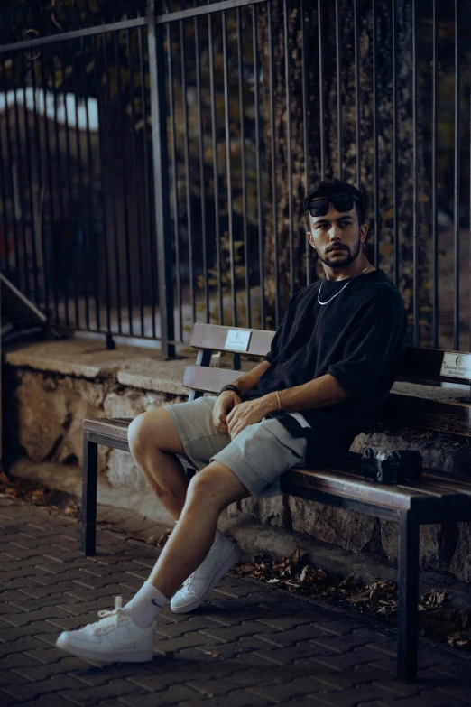 a young man sitting on top of a wooden bench