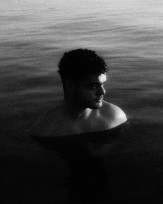 a man with a frisbee in his hand standing in the water