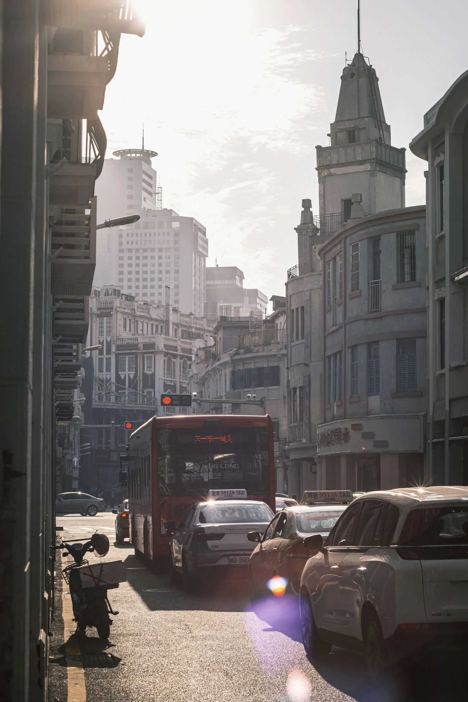 a bus traveling through a city next to parked cars