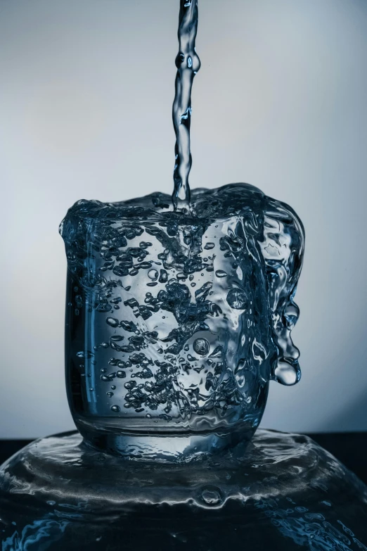 an ice bucket being filled with water from a sink