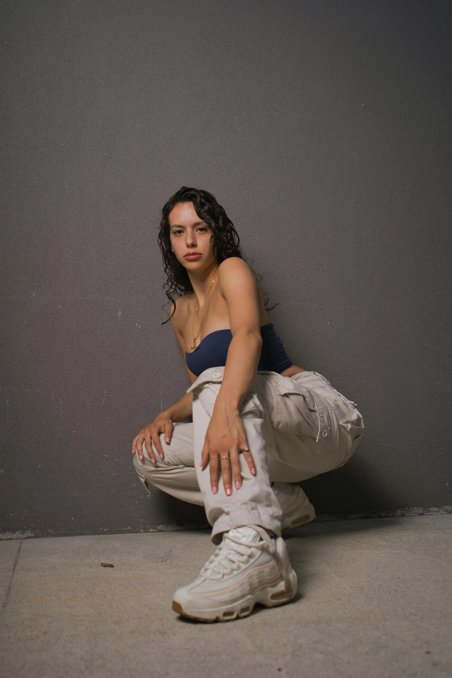 a woman sits on her knees and holds onto her jacket