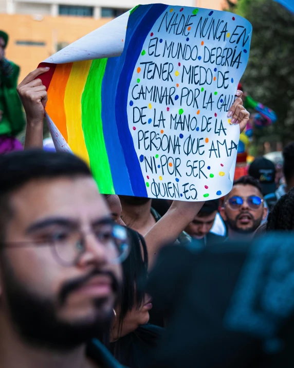 people holding rainbow colored signs in the air