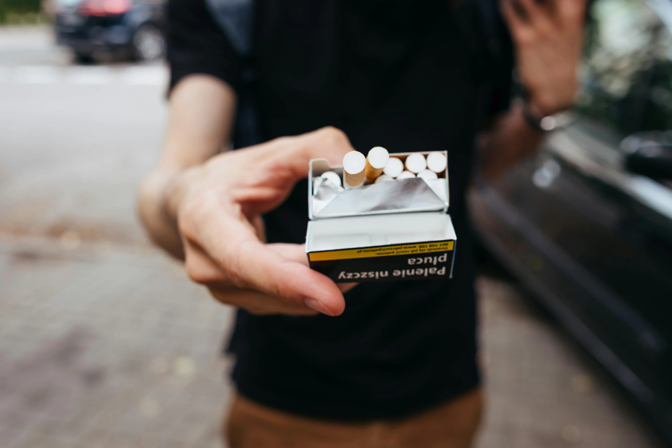 a cigarette is being held up in front of the man