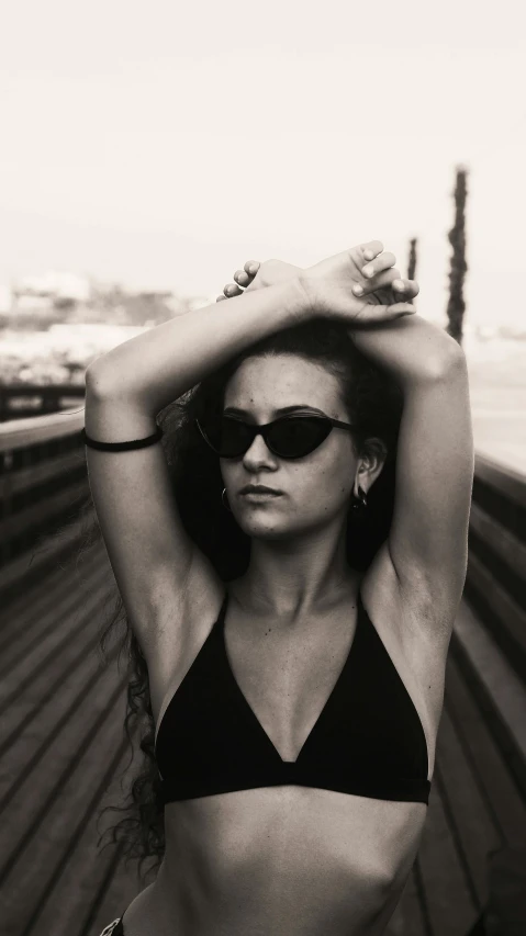 woman with sunglasses and headband in a bikini posing for the camera