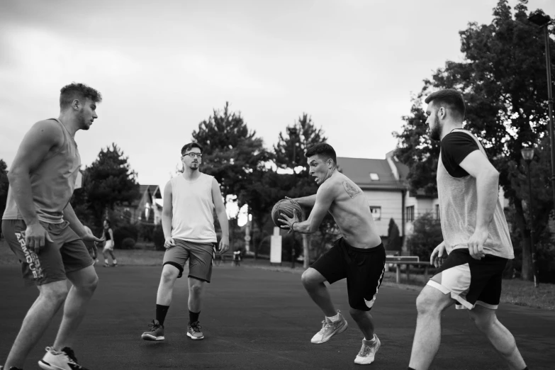 four men playing a game of frisbee on a park