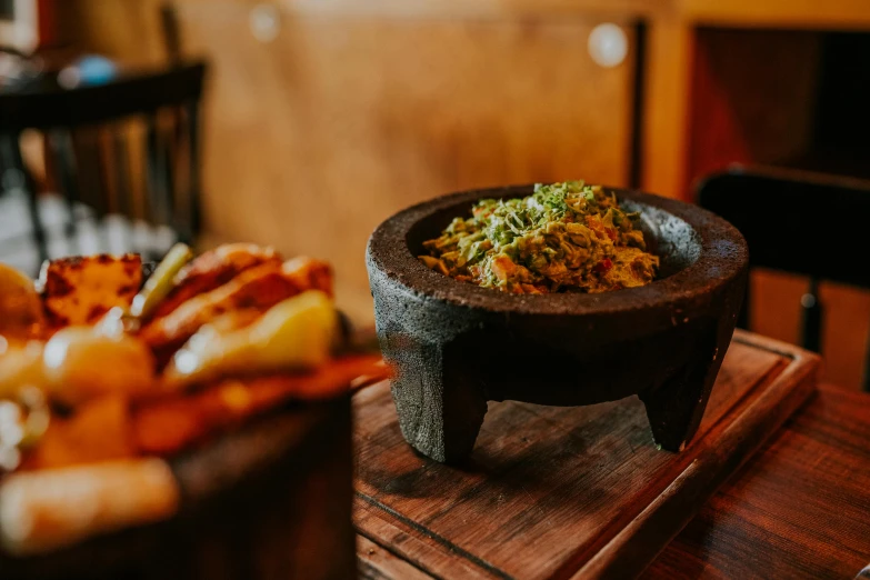 a bowl full of food sits on the table next to some other food