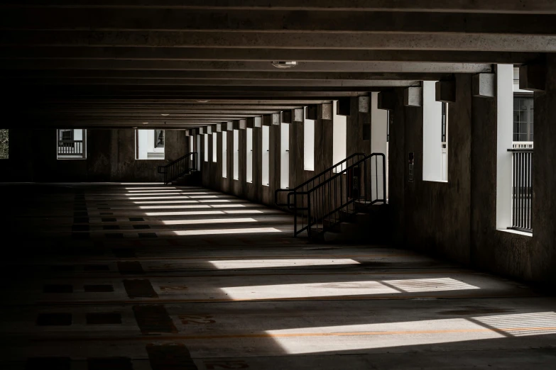 a long dark corridor has windows and bars