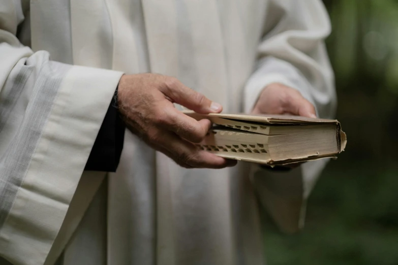 priest holding open book as he waits for the next performance