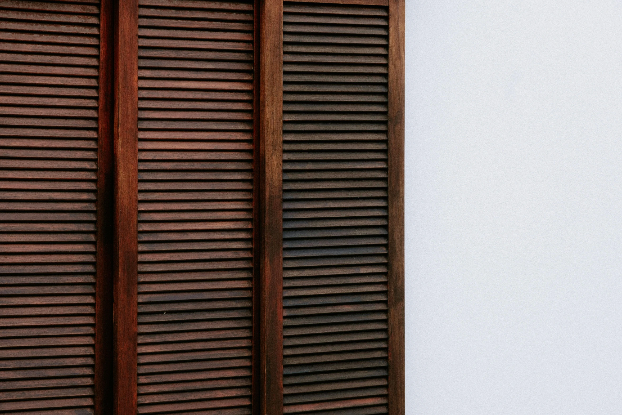 an open wooden window with slatted wood shutters