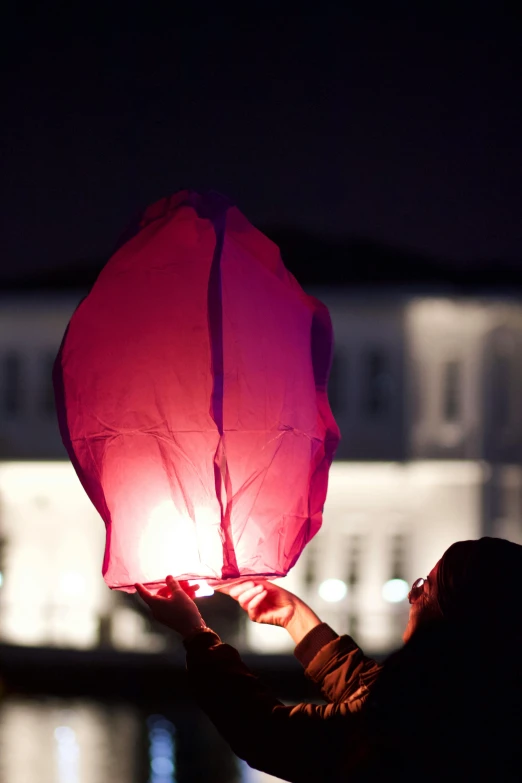 a person is holding up a lantern with water in front of them