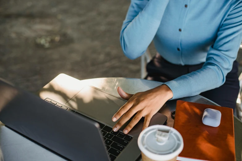 a woman sitting at a table on top of a laptop computer