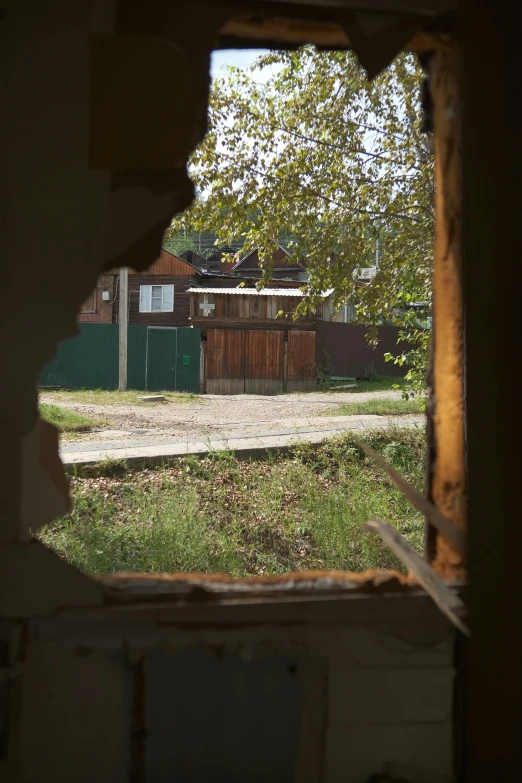 view out a hole in the wall looking at the yard