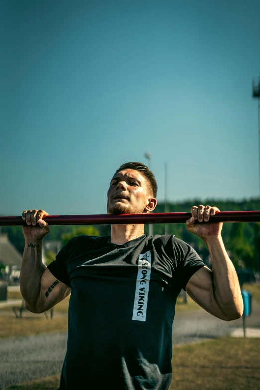 a man with his arms in the air doing pull - ups