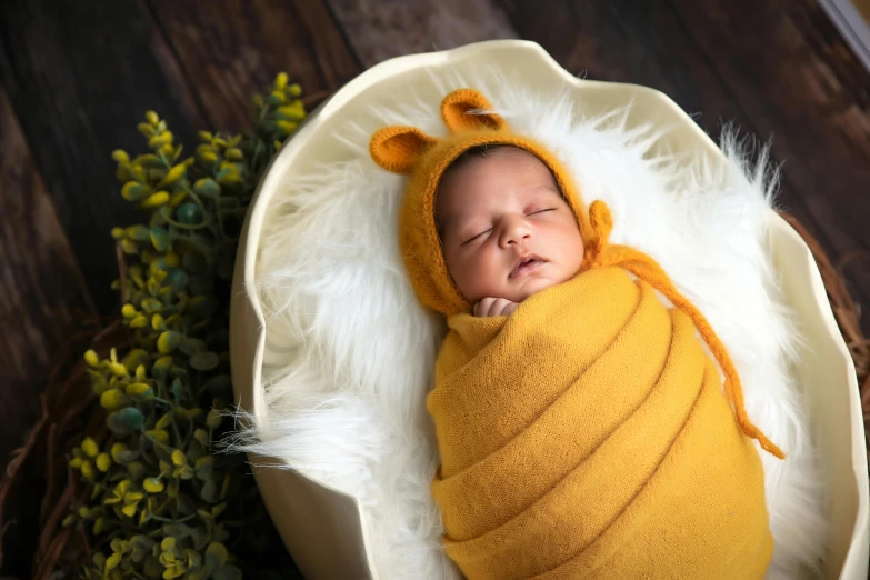 a baby in a blanket that has it's head on the end of a pillow