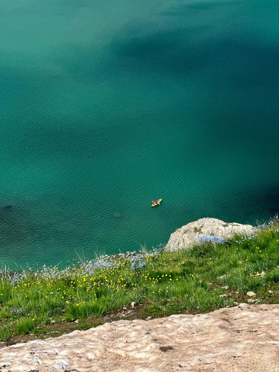 two boats float along the water on top of a hill