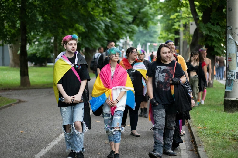 several people are walking down the sidewalk with a bright cape on