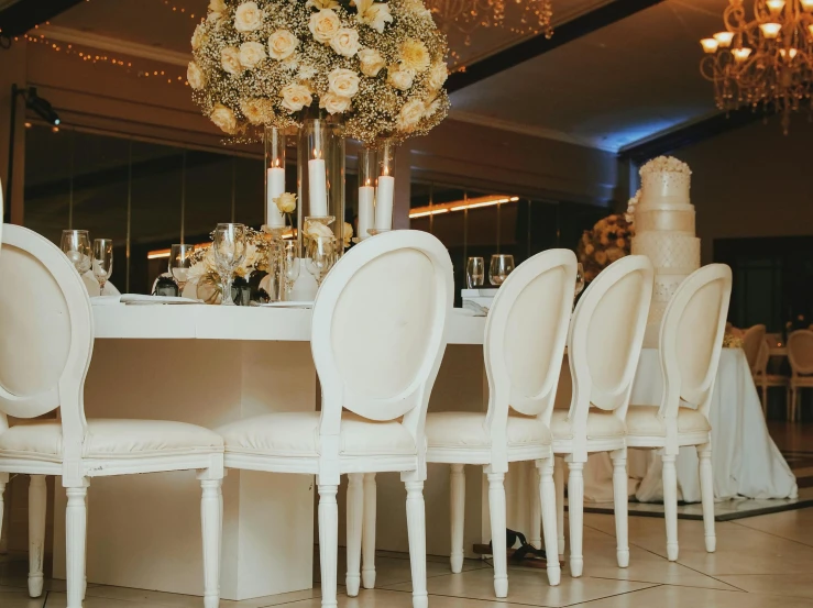 a table with several chairs with flowers in the middle