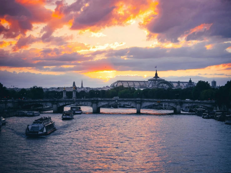 the sun sets over an embankment in paris