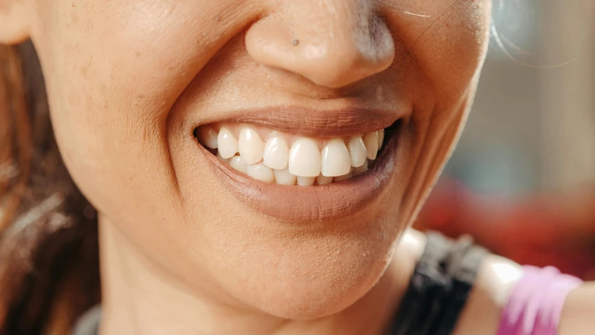 a smiling woman with a toothbrush in her mouth