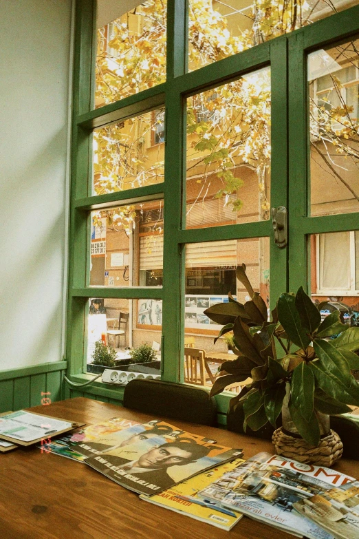 a wooden table in front of a window filled with magazines