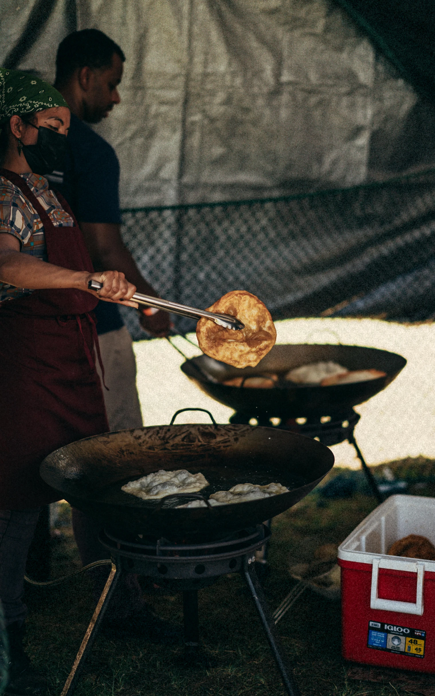 people in aprons are preparing food on grills