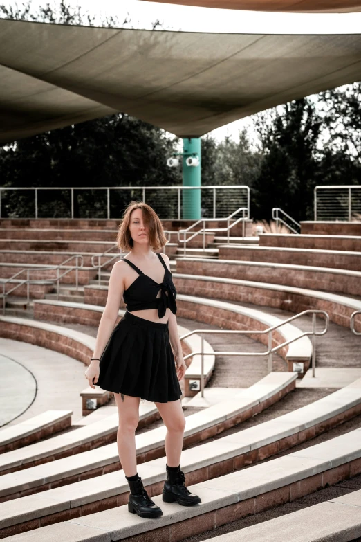a woman standing in front of the stairs of an outdoor arena