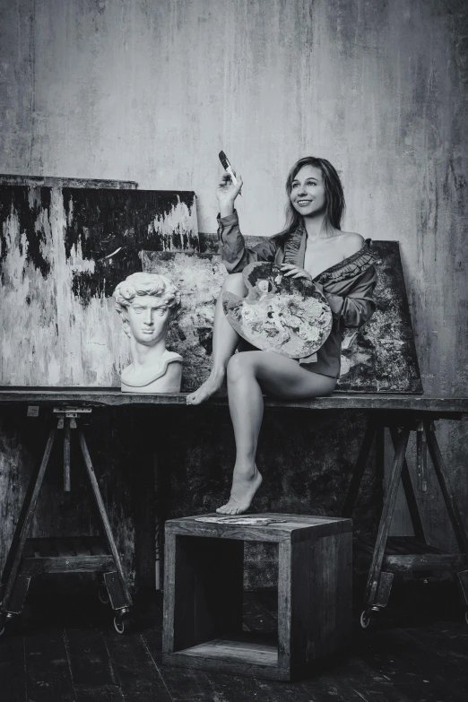 a black and white po of a woman painting on an easel