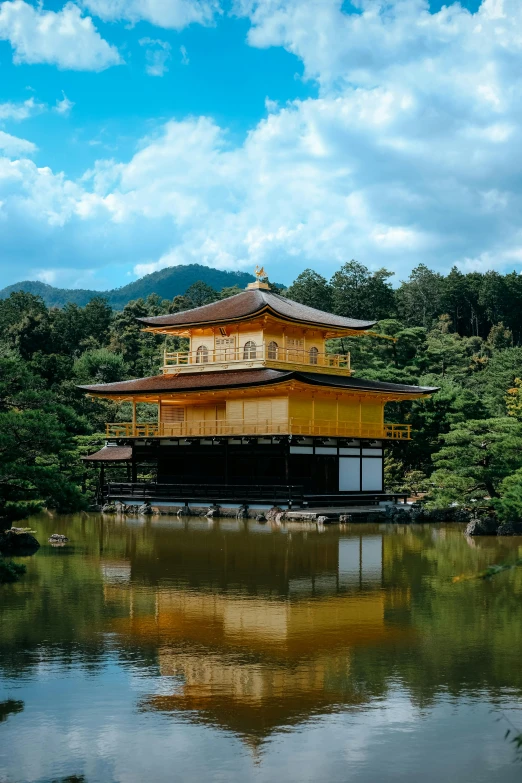 a beautiful pagoda on the water surrounded by green trees