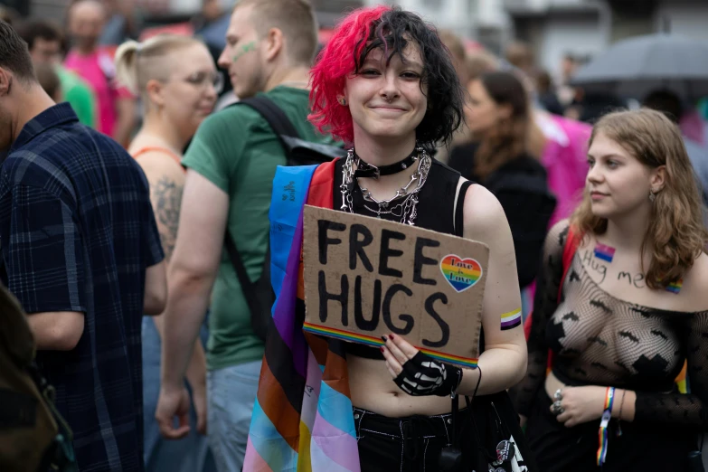 a man with red hair holding a free hugs sign