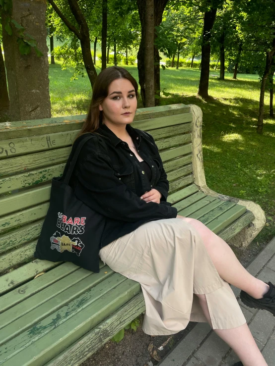 a woman is sitting on a bench with her leg propped up