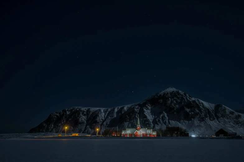 a view of some mountains at night with the moon in the sky