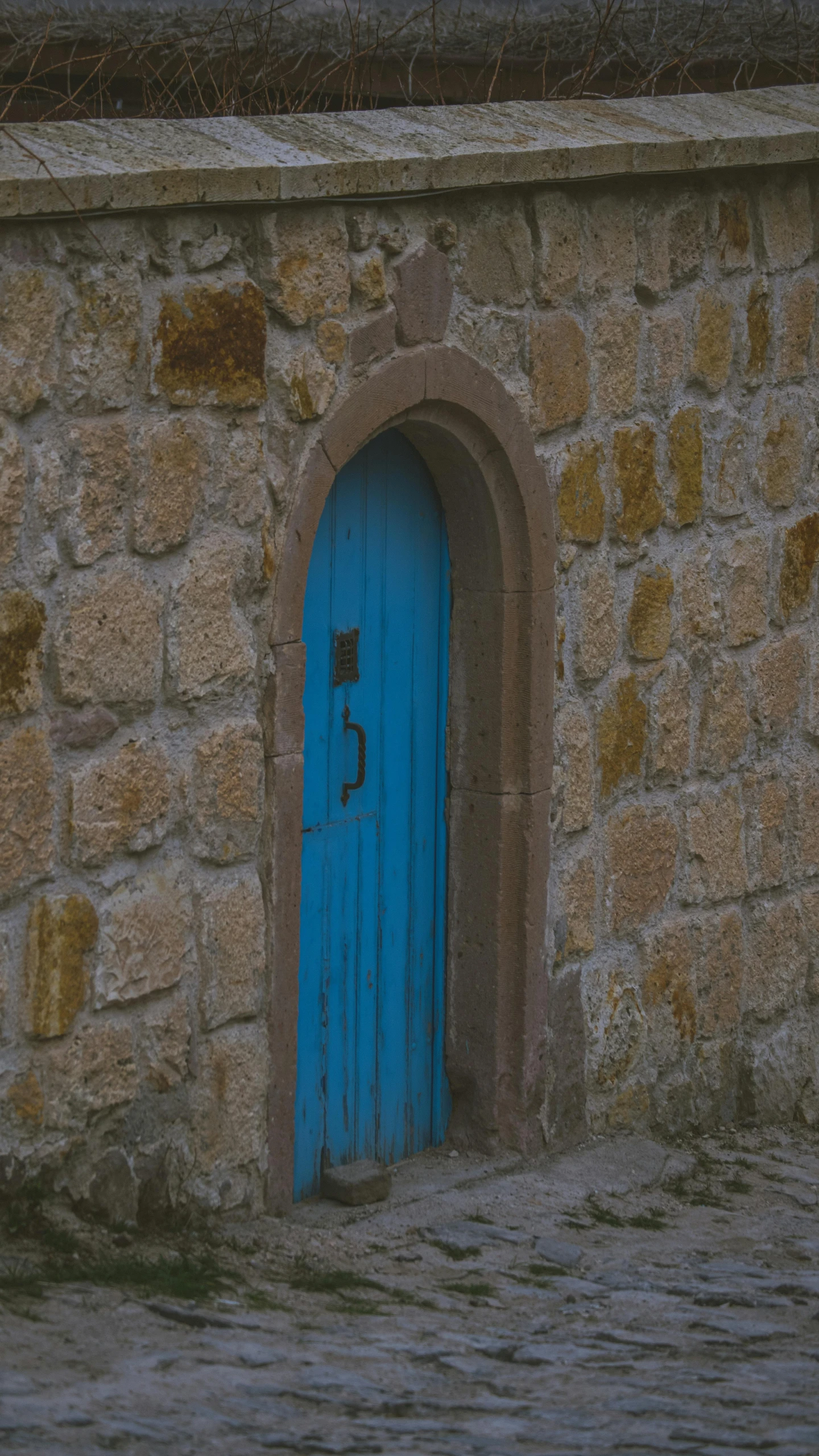 a door with a lock to it next to a stone wall