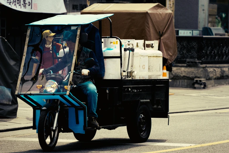 an indian tuk - tuk with a passenger in a cart in the street