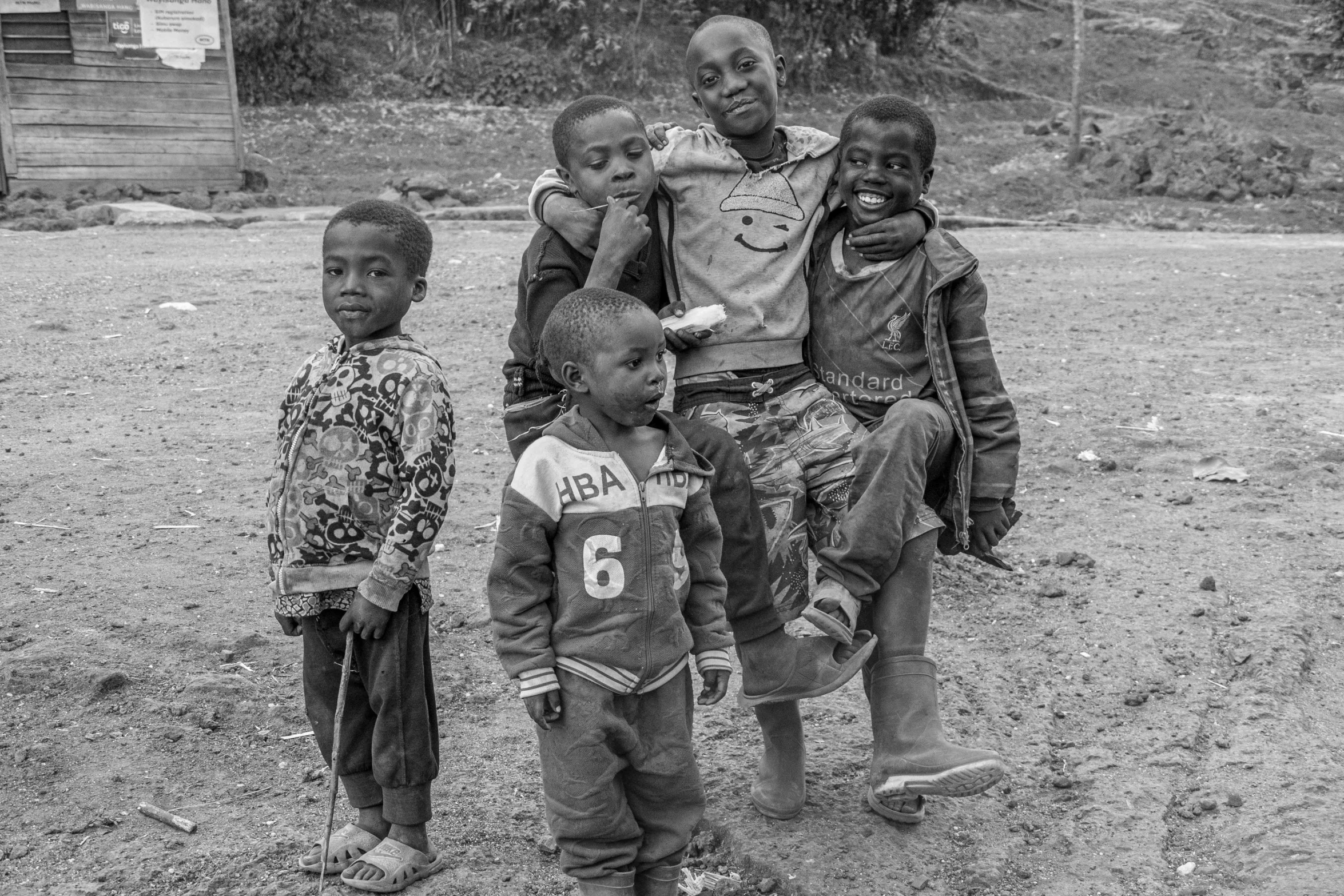 a man poses with his children on a dirt surface