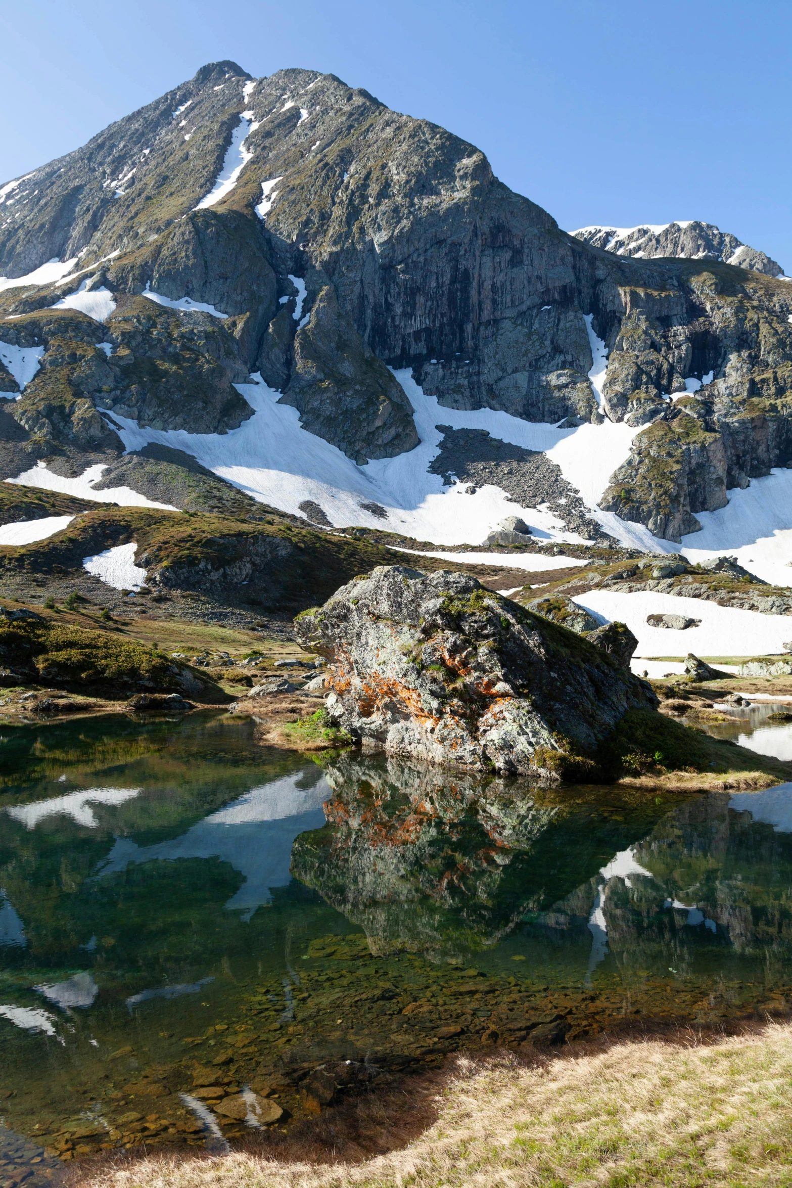 a mountain view with snow on the summit and water in it