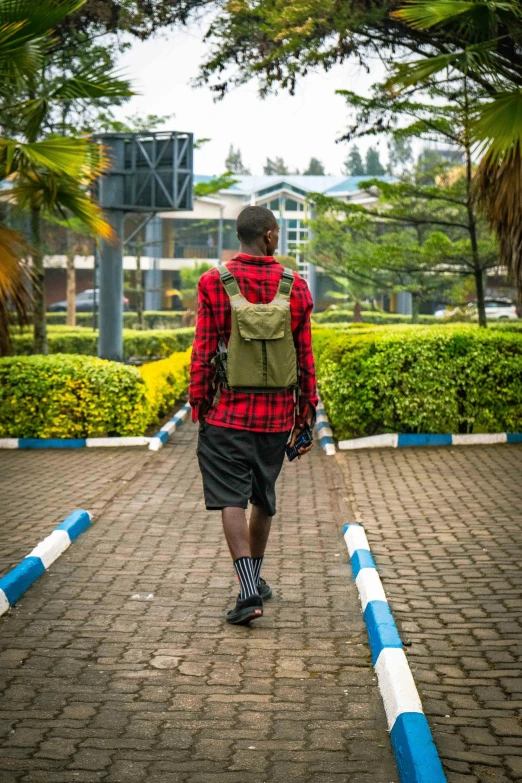 a young man in plaid jacket walking up a walkway