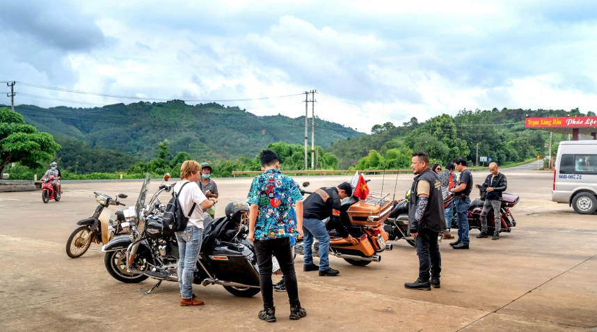 a group of people gathered together around motorcycles