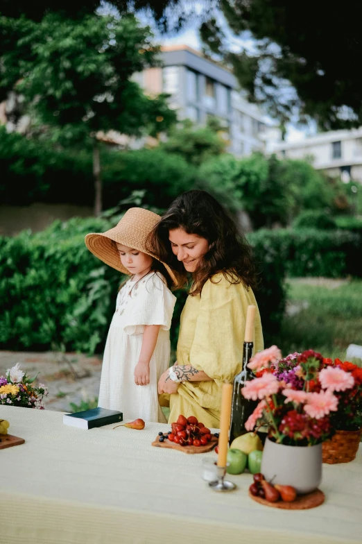 two girls looking at a flower arrangement on a table