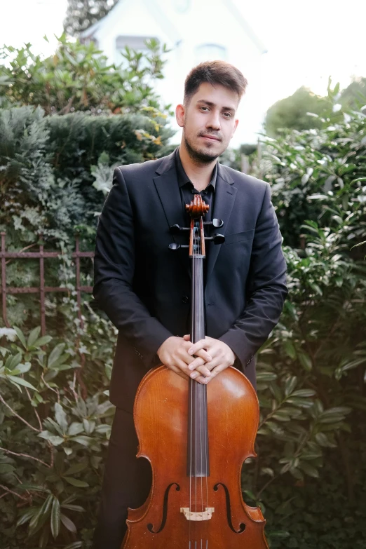 a man is holding an upright violin while posing