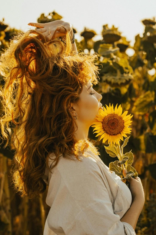 a woman is in the middle of a field with flowers