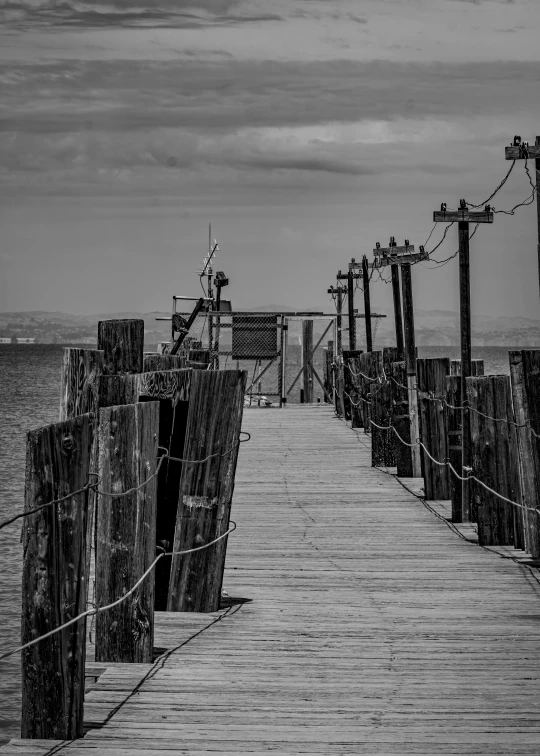 a black and white image of a fishing dock with ropes