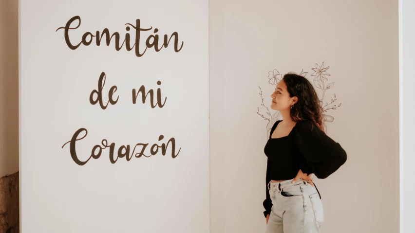 woman standing in front of large white sign next to wall