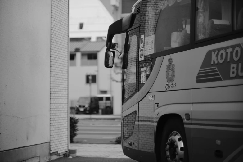 a black and white picture of a bus parked in front of some buildings