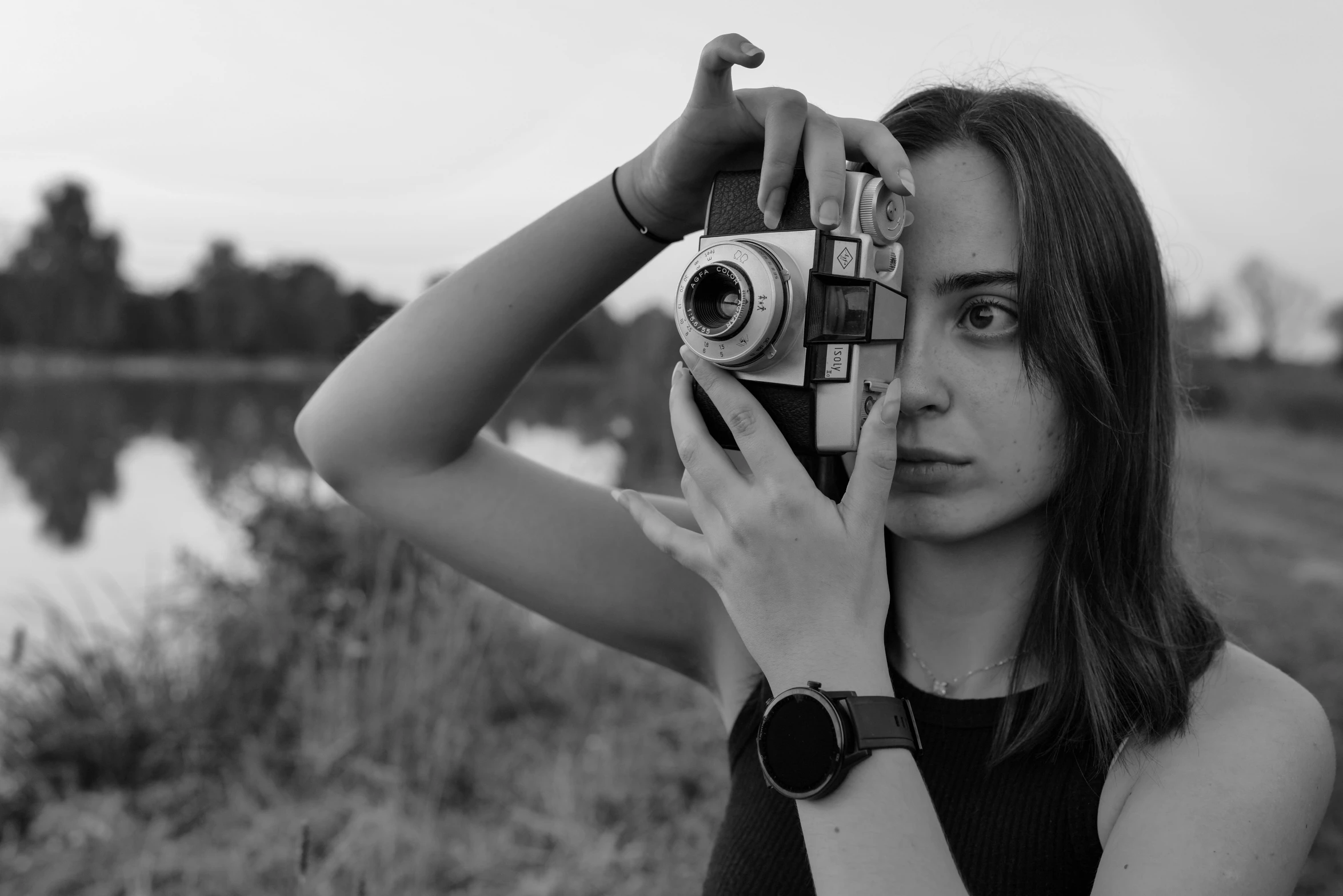 a woman is looking through a camera at the water