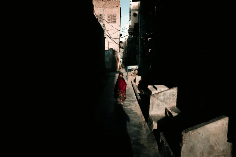 a woman walking down a narrow city street