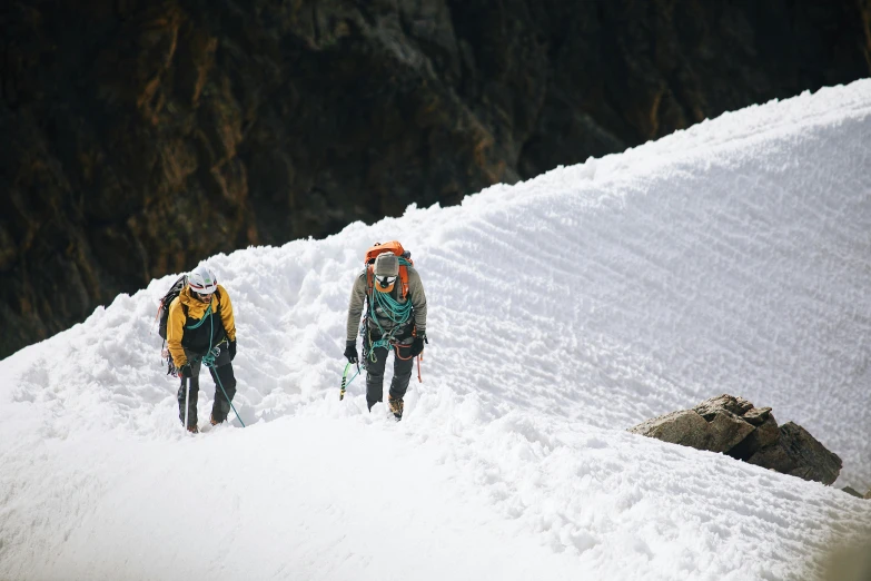 two people hiking up a snow covered mountain